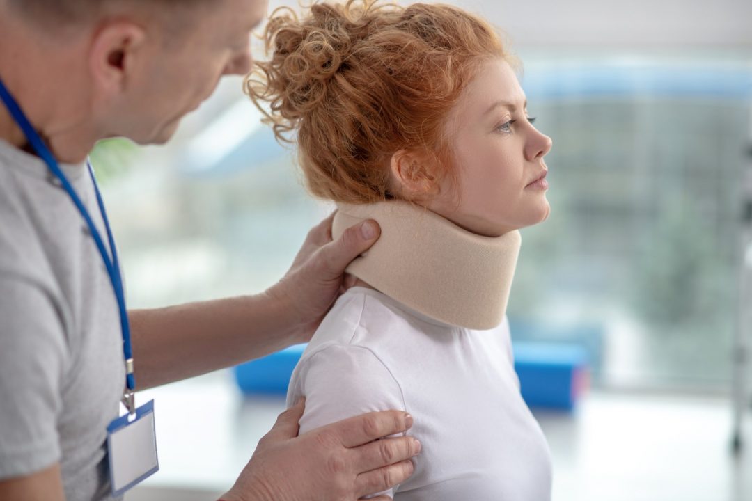 Male physiotherapist examining neck fixator of female patient - lighthouse chiropractic | family chiropractic center | fort collins, co | experienced practitioner professionals | fort collins chiropractic care & massage therapy